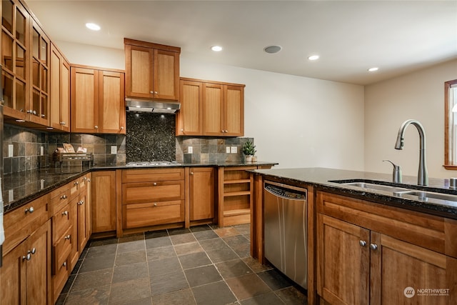 kitchen featuring dark tile patterned flooring, extractor fan, stainless steel appliances, sink, and decorative backsplash