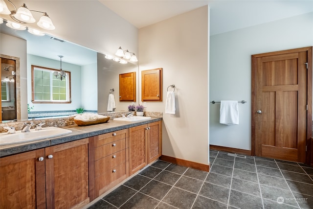 bathroom with double sink vanity, tile patterned floors, and an inviting chandelier