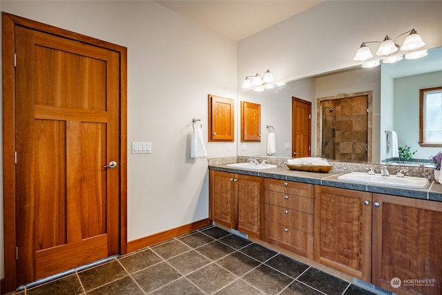 bathroom featuring a tile shower, dual vanity, and tile patterned flooring