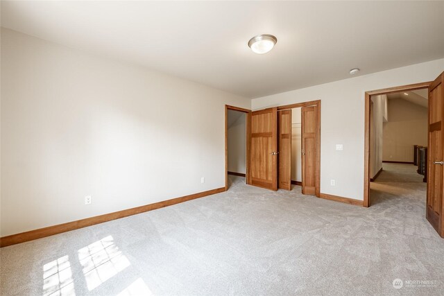 unfurnished bedroom featuring a closet and light colored carpet