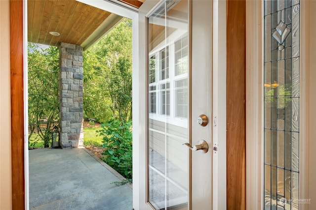 doorway with concrete floors and wooden ceiling