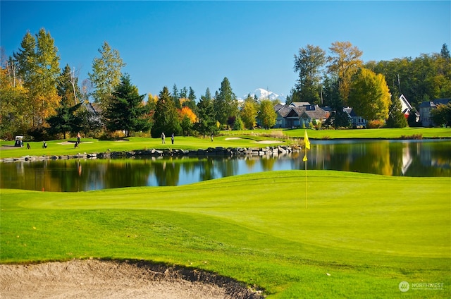 surrounding community featuring a water view and a lawn