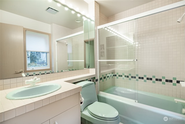 full bathroom featuring vanity, toilet, backsplash, and enclosed tub / shower combo