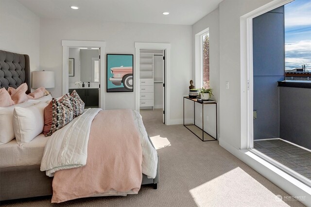 carpeted bedroom featuring connected bathroom and a walk in closet