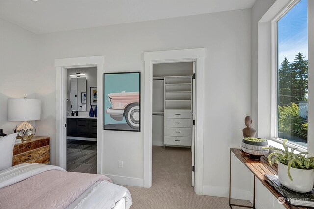 bedroom with a closet, carpet, and ensuite bathroom