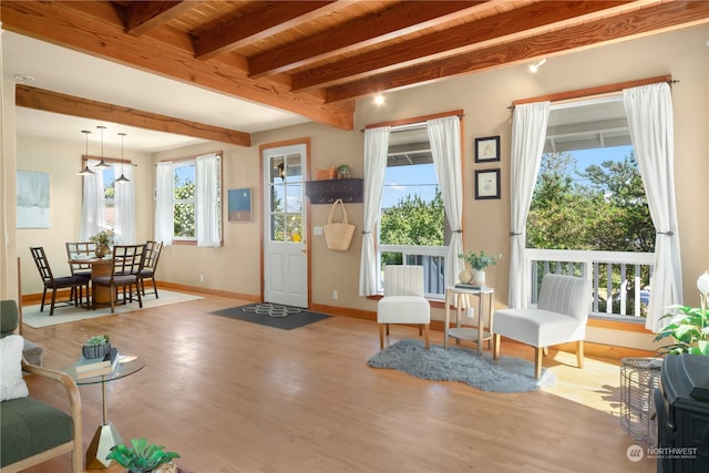 living room with beamed ceiling and light hardwood / wood-style floors