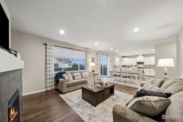 living room with dark hardwood / wood-style floors and a fireplace