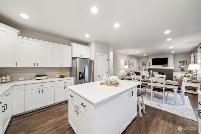 kitchen featuring recessed lighting, open floor plan, and stainless steel fridge with ice dispenser