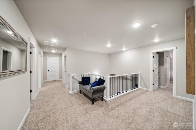 hallway featuring visible vents, carpet floors, baseboards, and an upstairs landing