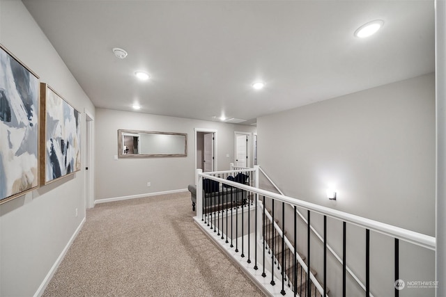 hall with recessed lighting, baseboards, carpet floors, and an upstairs landing