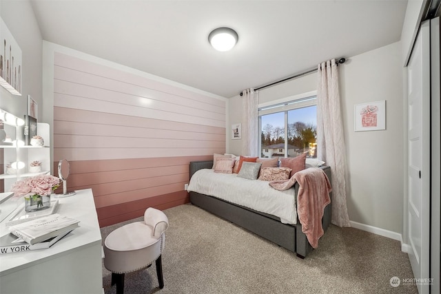 bedroom featuring wooden walls and carpet