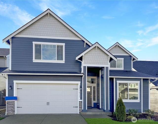 view of front of property featuring a garage, driveway, and a shingled roof