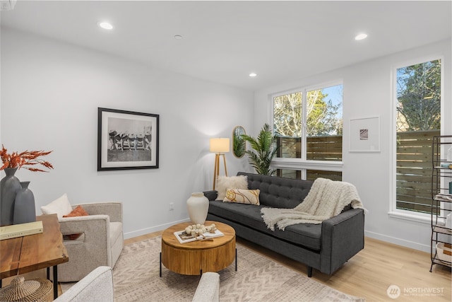 living room with light wood-type flooring, baseboards, and recessed lighting