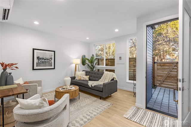 living room with light wood-style floors, recessed lighting, and baseboards