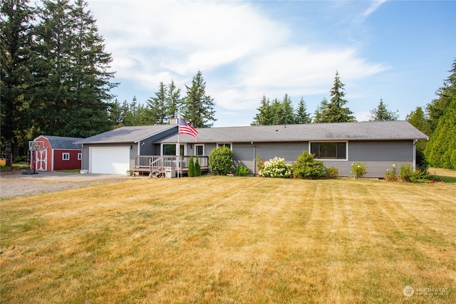 ranch-style house featuring a garage, a storage unit, and a front yard