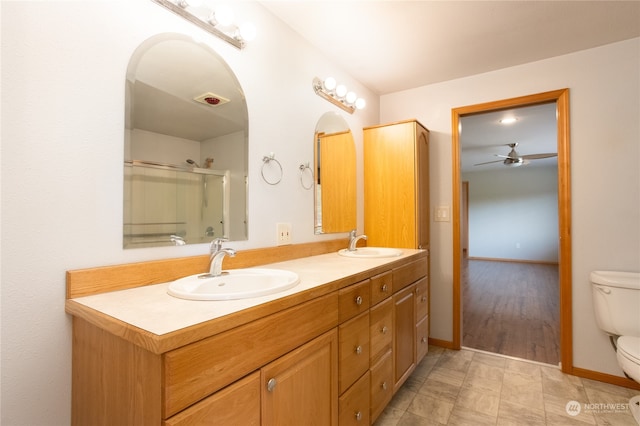 bathroom featuring tile patterned flooring, ceiling fan, toilet, and dual bowl vanity