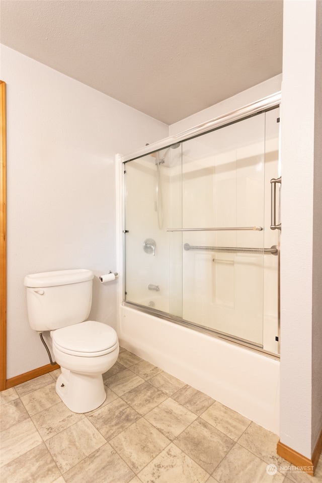 bathroom with tile patterned floors, toilet, and enclosed tub / shower combo