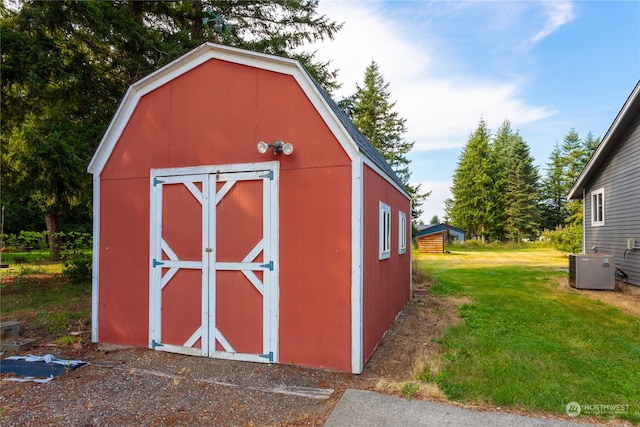 view of outdoor structure featuring a yard and central air condition unit