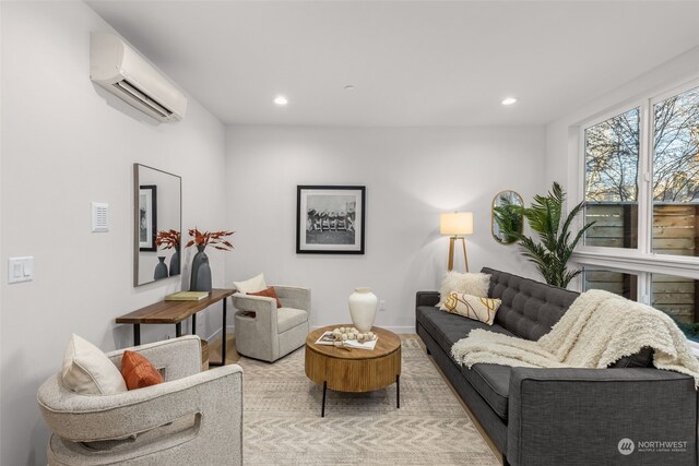 living room featuring a wall unit AC and light wood-type flooring