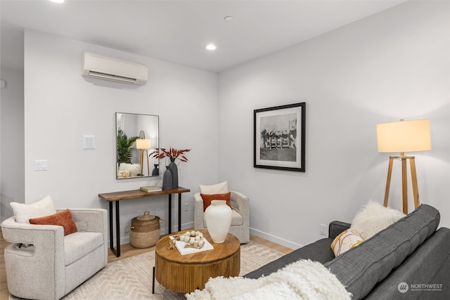 sitting room featuring an AC wall unit and light hardwood / wood-style flooring