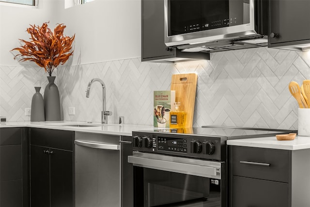 8045G Mary Ave NW, Seattle, WA 98117 - kitchen featuring appliances with stainless steel finishes, tasteful backsplash, light countertops, a sink, and dark cabinetry