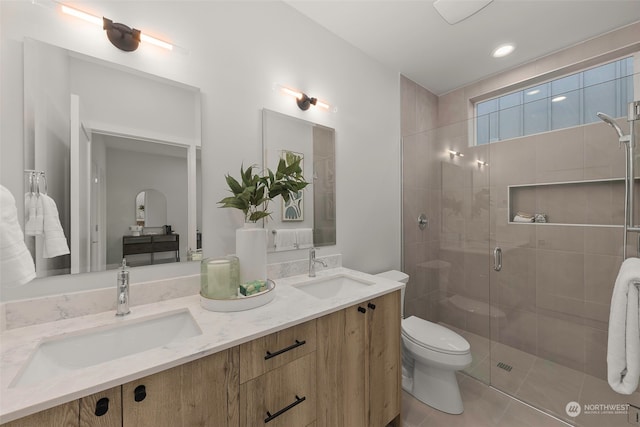 bathroom with walk in shower, vanity, tile patterned floors, and toilet