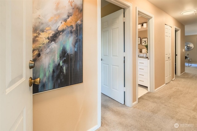 hall featuring baseboards and carpet