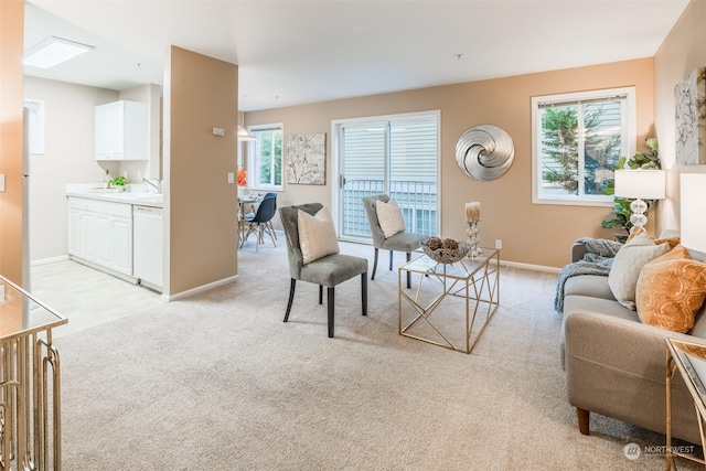 living area featuring baseboards and light carpet