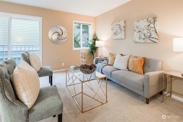 carpeted living area featuring baseboards