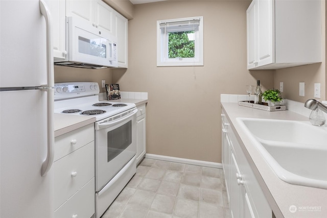 kitchen featuring white appliances, baseboards, a sink, light countertops, and white cabinetry