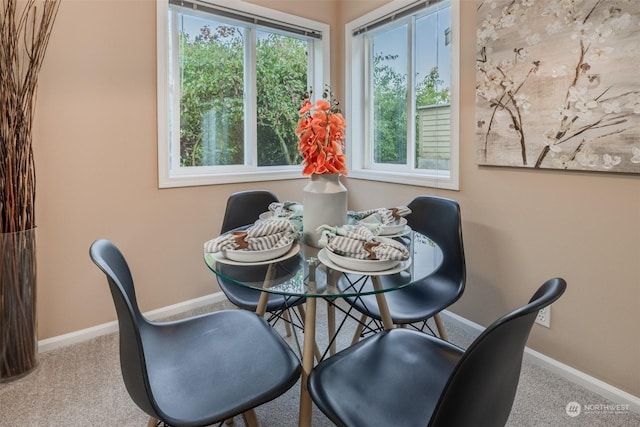 carpeted dining room featuring baseboards