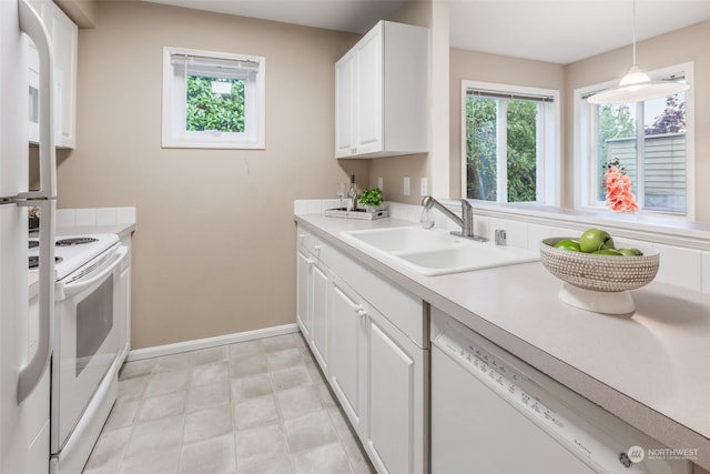 kitchen featuring white appliances, baseboards, a sink, light countertops, and white cabinets