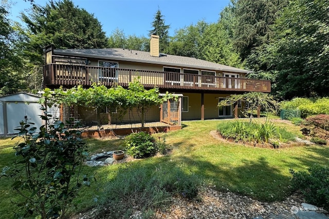 back of house featuring a lawn and a wooden deck