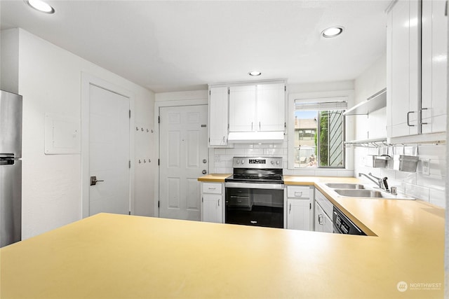 kitchen featuring electric stove, sink, white cabinets, decorative backsplash, and kitchen peninsula