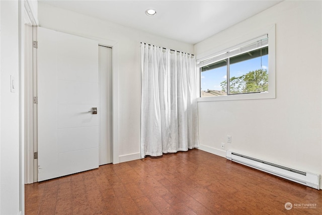 unfurnished bedroom featuring a baseboard radiator and hardwood / wood-style floors