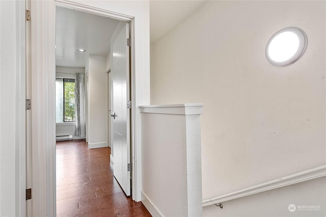 hall featuring baseboard heating and dark hardwood / wood-style flooring