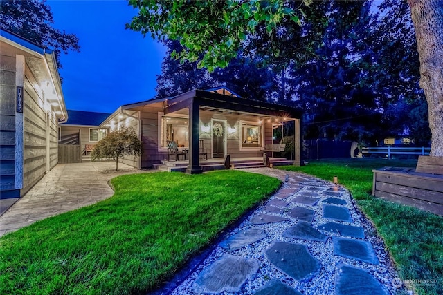 rear view of house featuring a yard, a patio area, and covered porch