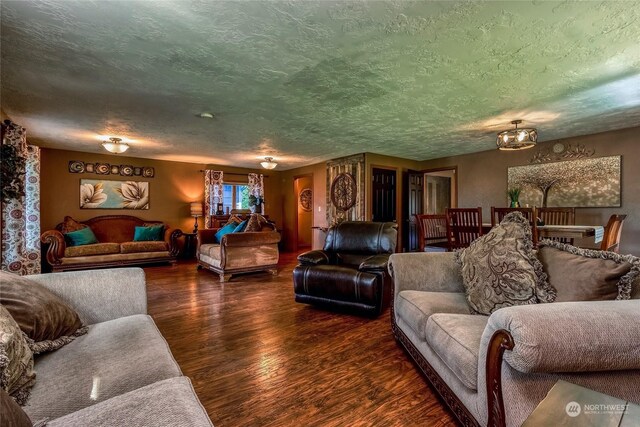 living room featuring a textured ceiling and dark hardwood / wood-style flooring