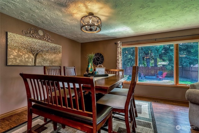 dining area with hardwood / wood-style flooring and a textured ceiling