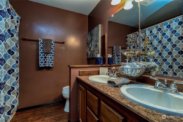 bathroom featuring vanity, hardwood / wood-style floors, and toilet