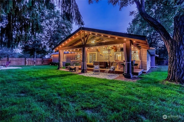 back house at dusk with a lawn