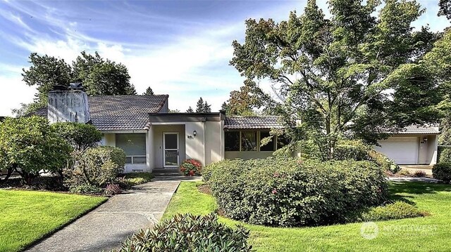 view of front of property with a garage and a front lawn