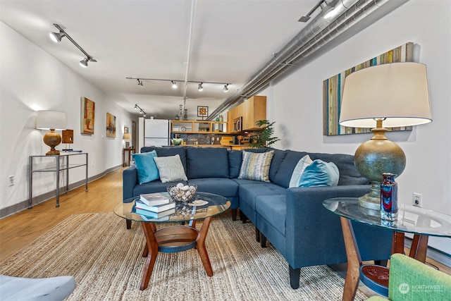 living room featuring rail lighting and light hardwood / wood-style floors