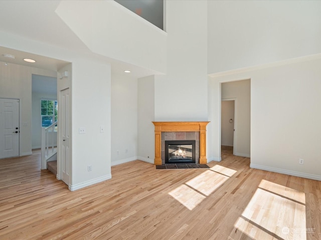 unfurnished living room featuring baseboards, a fireplace, and light wood finished floors