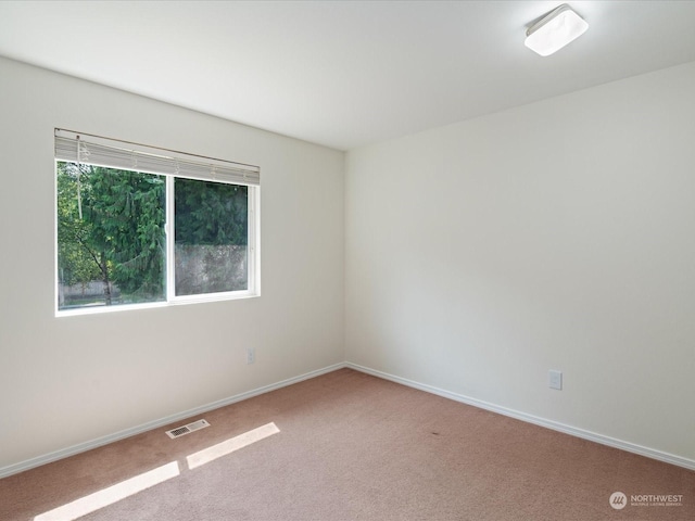 carpeted empty room with visible vents and baseboards