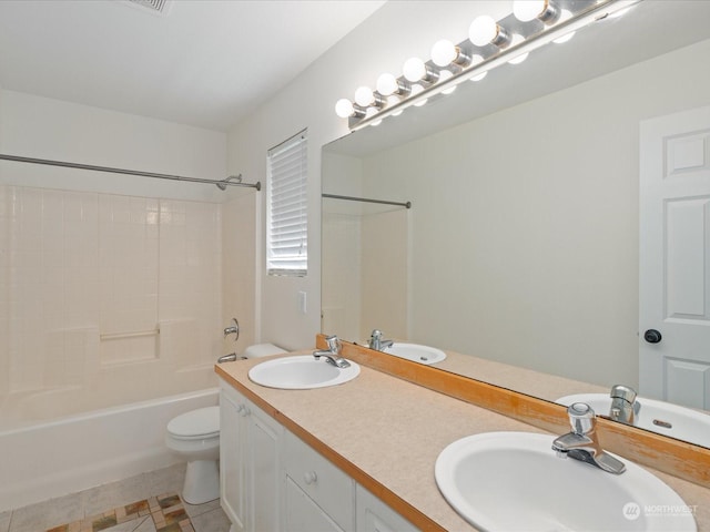 bathroom with double vanity, a sink, and toilet