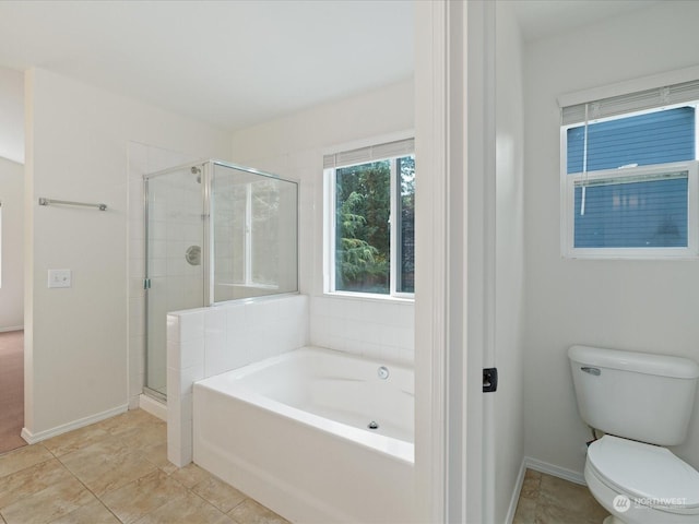 bathroom with a garden tub, a shower stall, toilet, and baseboards