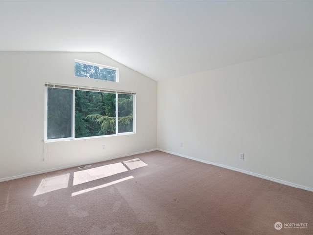 unfurnished room with vaulted ceiling, baseboards, visible vents, and light colored carpet