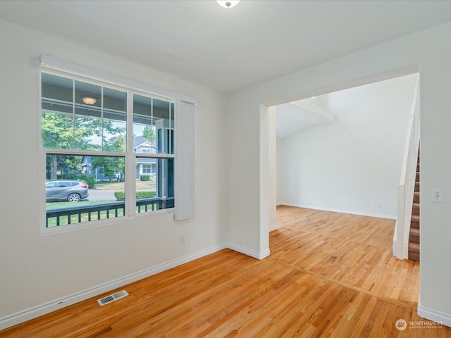 spare room with stairs, visible vents, baseboards, and wood finished floors