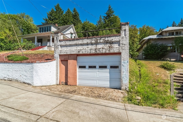 view of front of property with a porch, a garage, and a front lawn